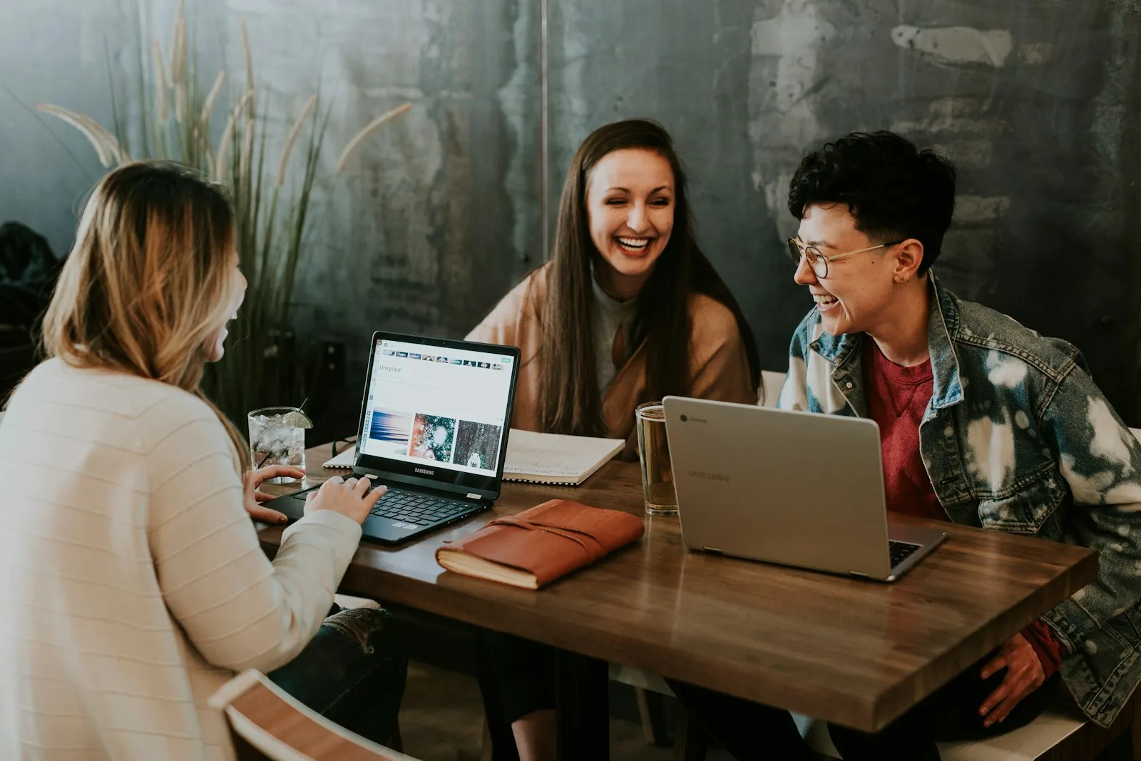 A marketing team collaborating on an event campaign around shared laptops