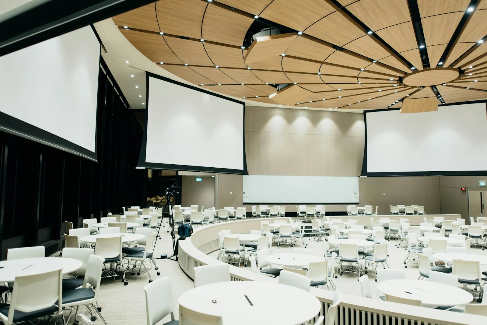 A conference hall set with tables and screens, ready for mixed ticket types