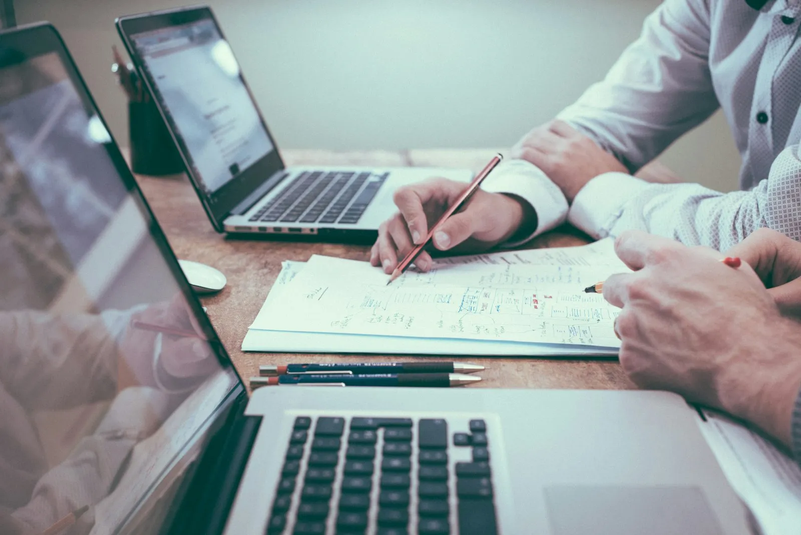 An organizer mapping the registration funnel on paper beside a laptop